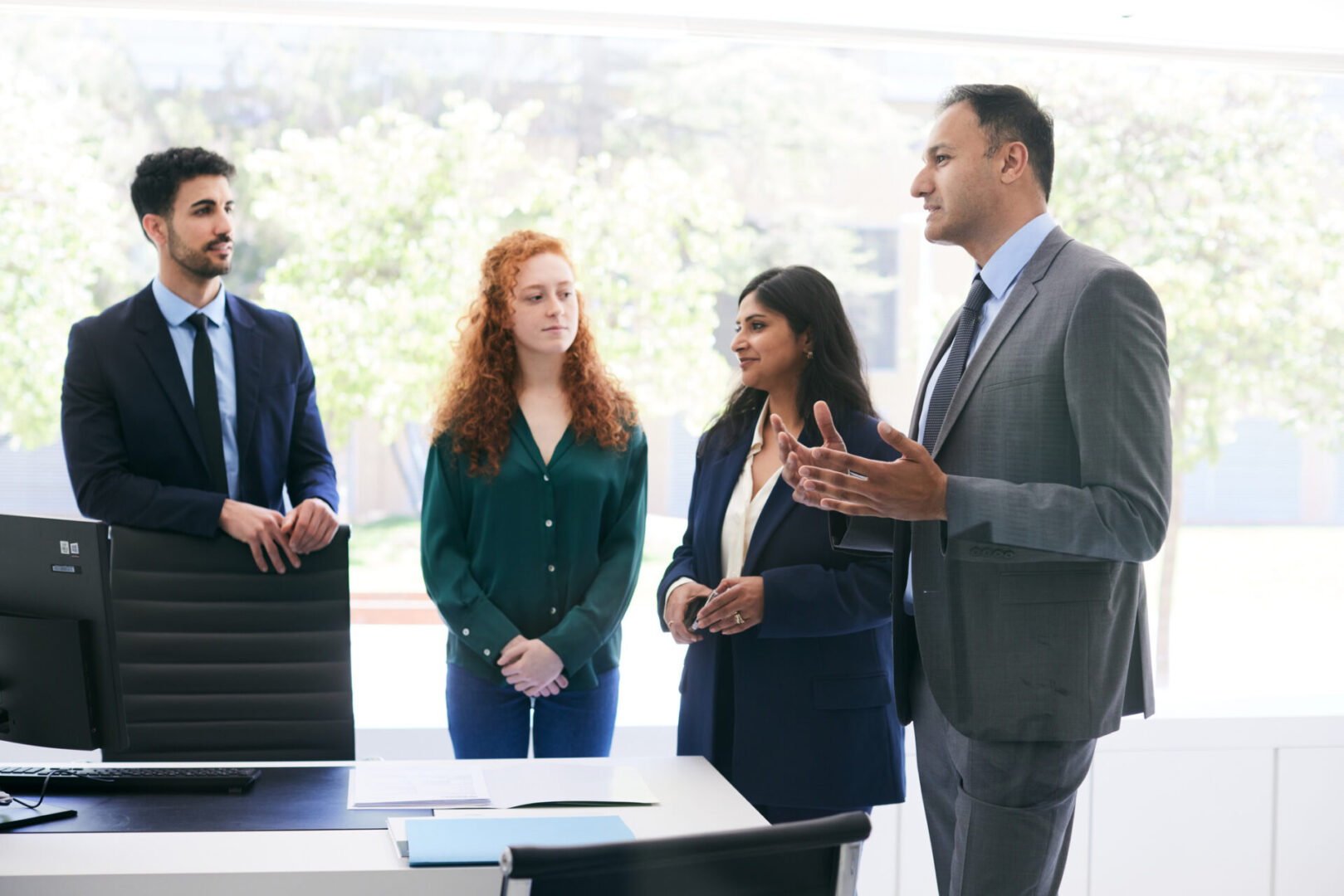 Four professionals having a discussion in office.