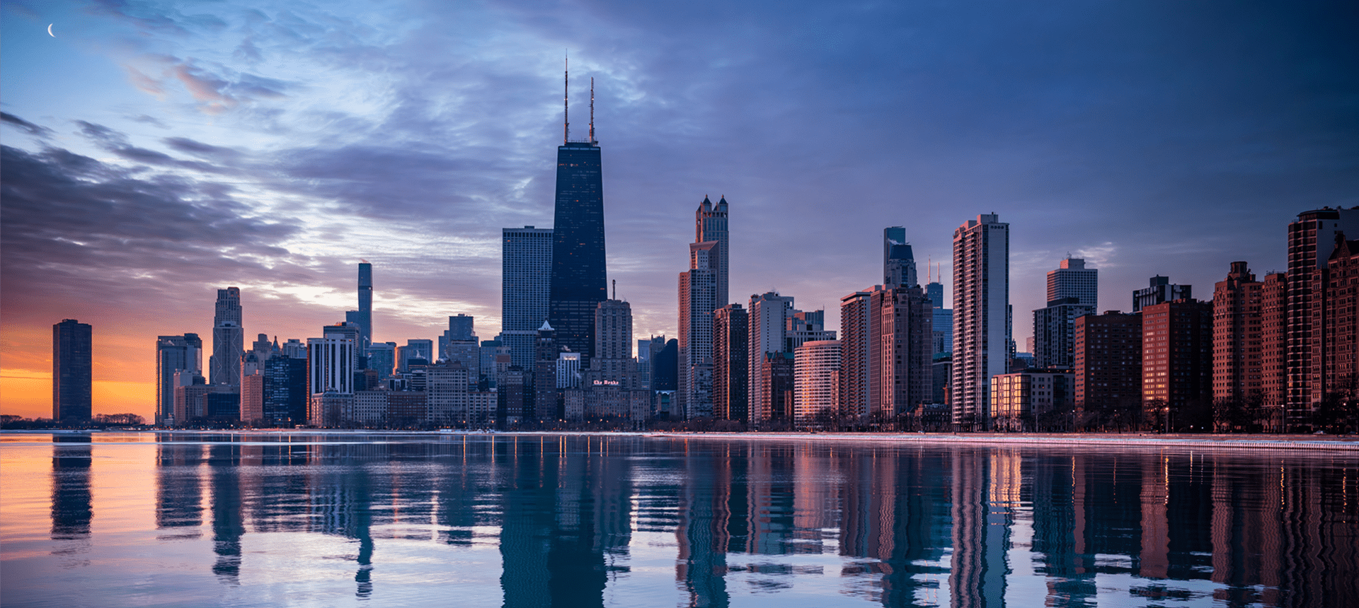 Chicago skyline at sunrise with reflections.